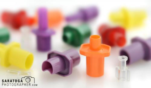Close up of tiny various colored plastic blow molded parts by Bard manufacturing